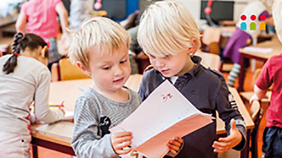 Twee kinderen in de klas met papier in hun hand